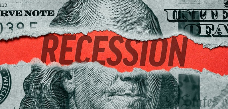 Torn edges peel back layers of a U.S. $100 bill to expose the word “Recession” in bold letters—an urgent visual metaphor for looming economic turmoil and financial instability.